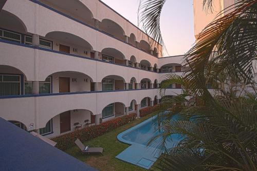 an external view of a hotel with a swimming pool at Hotel Arcos Aeropuerto in Veracruz