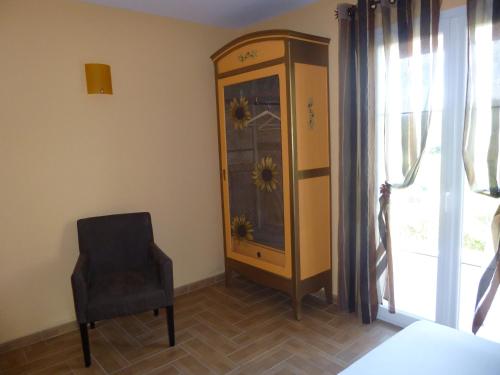 a room with a chair and a cabinet with flowers on it at Domaine de Flo ADULT a partir de 16 ans in Saint-Jean-de-la-Blaquière