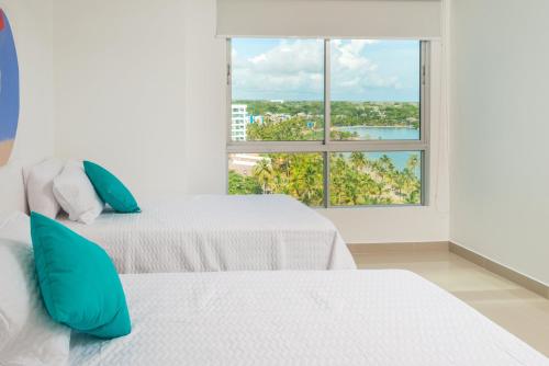 two beds in a room with a large window at Magico Apartamento Frente al Mar 3 Habitaciones AR91 in Pativilca