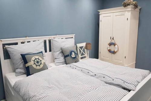 a bedroom with a white bed with blue walls and pillows at GUESTHOUSE MARIA / КЪЩА ЗА ГОСТИ МАРИЯ / GÄSTEHAUS MARIA in Karlovo