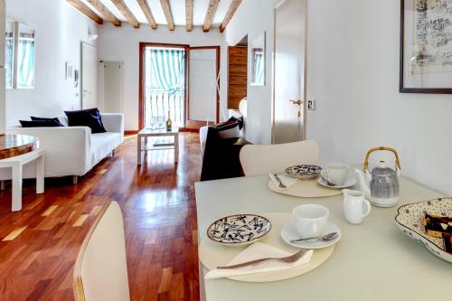 eine Küche und ein Wohnzimmer mit einem Tisch und Stühlen in der Unterkunft CA ANGELA VENETIAN APARTMENT M0270428215 in Venedig