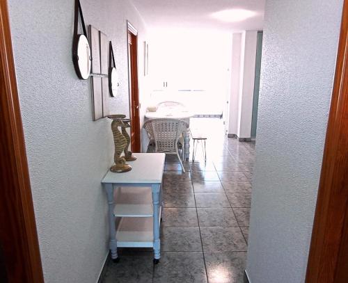 a room with a table with a lamp on it at Apartamento mediterraneo, muy centrico, en Plaza Triangular, soleado, con jardines y piscina y la playa enfrente andando, con parking exterior comunitario in Benidorm