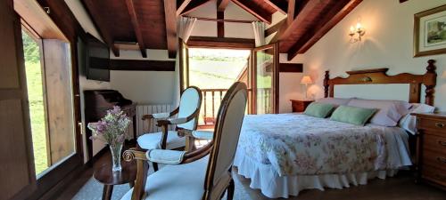 a bedroom with a bed and chairs and a window at Posada El Bosque in Mieses