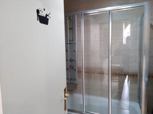 a shower with a glass door in a bathroom at APARTAMENTO HISTORICO LLANES in Llanes