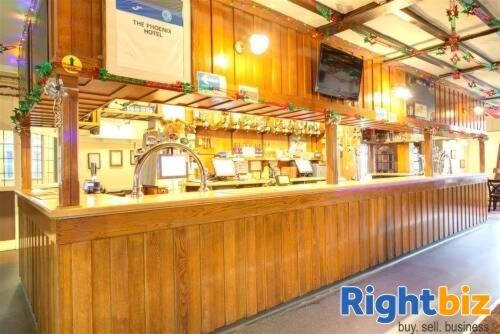 een houten bar in een restaurant met een bar bij Phoenix Hotel in Chard