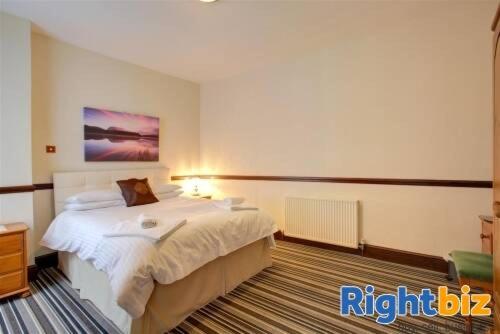 ein Schlafzimmer mit einem Bett und einem Wandgemälde in der Unterkunft Phoenix Hotel in Chard
