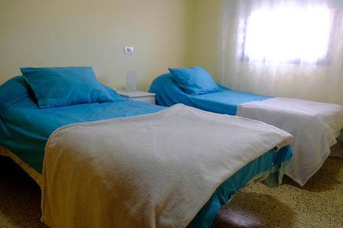 a room with two beds with blue sheets and a window at Molinos II - Casitas Las Abuelas in Santa Cruz de la Palma