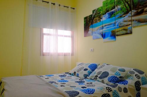 a bedroom with a bed with blue and white sheets and a window at Molinos II - Casitas Las Abuelas in Santa Cruz de la Palma