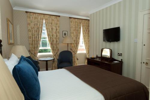 a hotel room with a bed and a television at Flitwick Manor Hotel in Flitwick