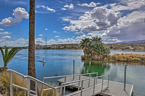 a dock on a river with a boat in the water at Restful Riverfront Retreat with Private Dock and Patio in Bullhead City
