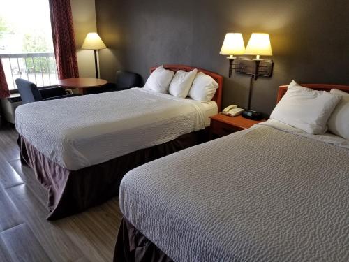 a hotel room with two beds and a table at Days Inn by Wyndham Wilson in Wilson