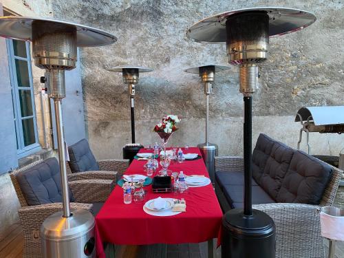 una mesa con un mantel rojo y algunas luces en LE CHARME DE ST PIERRE en Saint-Pierre-le-Moûtier