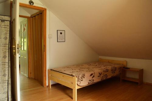 a small bedroom with a bed and a staircase at Zacisze nad Sanem Załuż 129 in Załuż