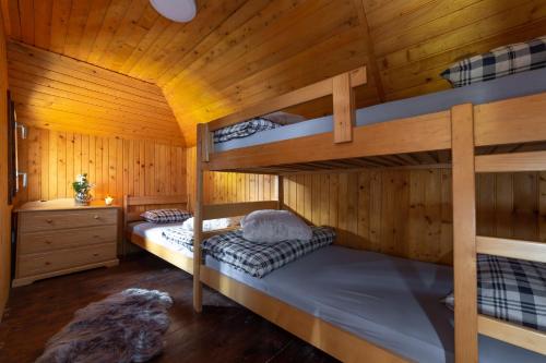 a bedroom with two bunk beds in a wooden cabin at Chalet Neza Velika Planina in Stahovica