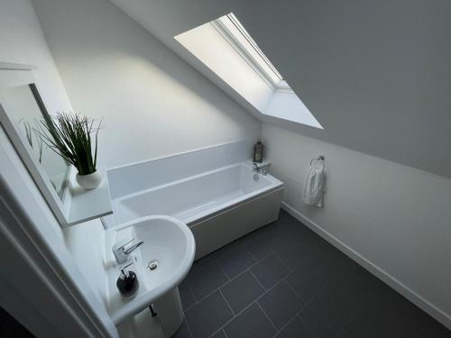a bathroom with a sink and a tub and a skylight at The Old Stables 17a in Dumfries