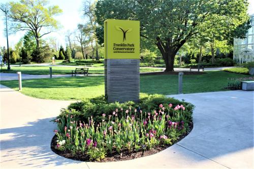 a sign for a park with flowers in a garden at Chic 2BR near DT, 8 min walk to Park&Conservatory in Columbus