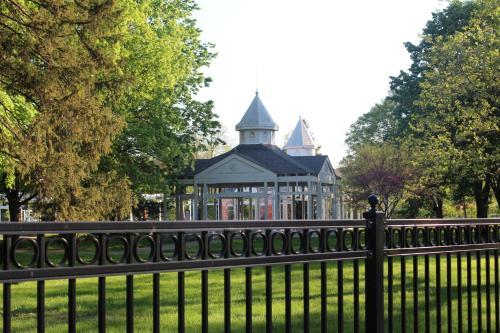 a fence in front of a park with a gazebo at Chic 2BR near DT, 8 min walk to Park&Conservatory in Columbus