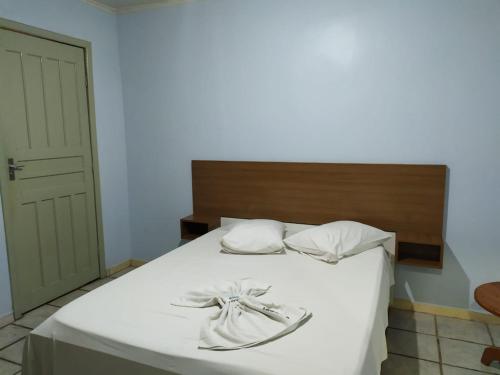 a bedroom with a bed with white sheets and white pillows at HOTEL GARCIA in Várzea Grande