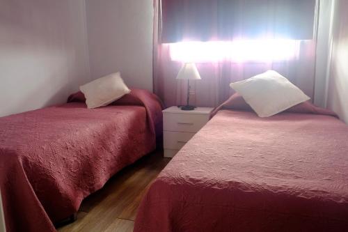 1 dormitorio con 2 camas y mesa con lámpara en Duplex Belmaco - Casitas las Abuelas en Santa Cruz de la Palma