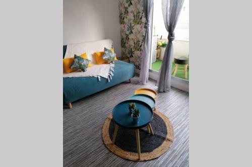 un salon avec un canapé bleu et une table dans l'établissement STUDIO 150M DE LA PLAGE DES DEMOISELLES, à Saint-Hilaire-de-Riez