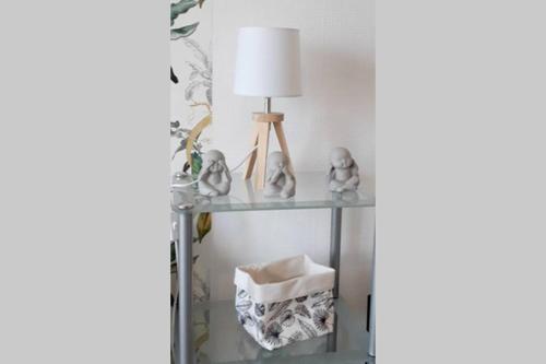 une étagère en verre avec une lampe et d'autres articles sur celle-ci dans l'établissement STUDIO 150M DE LA PLAGE DES DEMOISELLES, à Saint-Hilaire-de-Riez