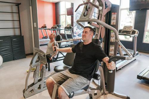 a man sitting on a treadmill in a gym at ibis Caxias do Sul in Caxias do Sul