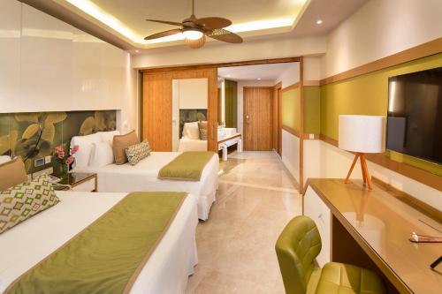 a hotel room with two beds and a tv at Dreams Onyx Resort & Spa - All Inclusive in Punta Cana