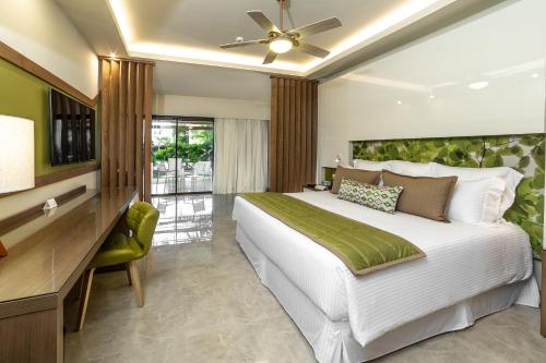 a bedroom with a large white bed and a desk at Dreams Onyx Resort & Spa - All Inclusive in Punta Cana