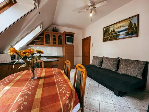ein Wohnzimmer mit einem Tisch und einem Sofa in der Unterkunft Casa Fiore By BLTN Balatonlelle in Balatonlelle