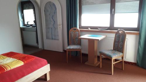 a bedroom with a bed and a table and two chairs at Emi in Klagenfurt