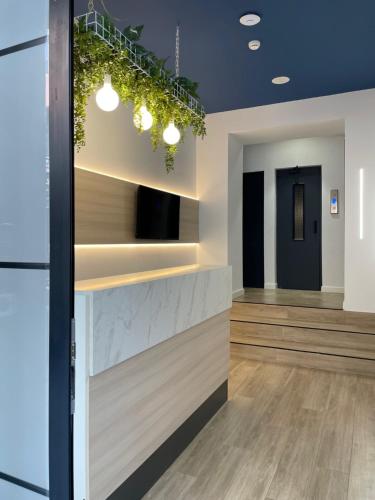 a lobby with a waiting area with plants on the wall at LC Hotel Urbano in Alicante