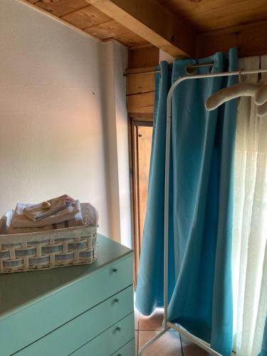 een slaapkamer met een blauw gordijn en een dressoir bij Casa CINEMA in Bergamo