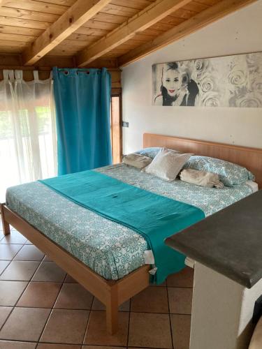 een bed in een kamer met een blauw gordijn bij Casa CINEMA in Bergamo