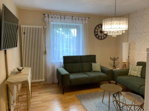 a living room with a green couch and a table at Ferienhaus -HAUS DER WEICHSEL- bei Lauingen, mit Sauna in Veitriedhausen