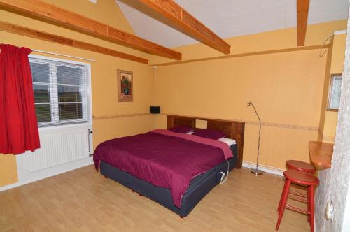 1 dormitorio con cama, ventana y silla en Hustugu Gård, en Örsundsbro