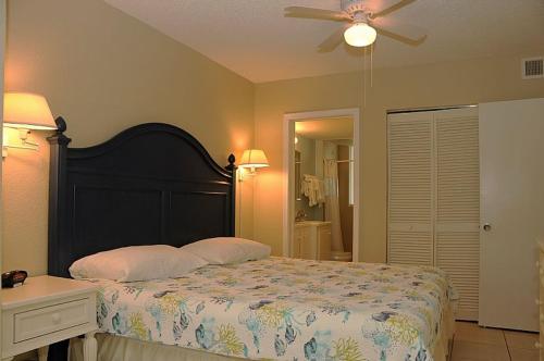 een slaapkamer met een bed en een plafondventilator bij Berkshire by the Sea in Delray Beach