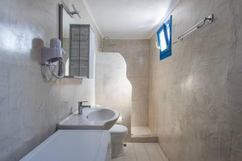 a bathroom with a white toilet and a sink at Eva's Guesthouse in Éxo Goniá