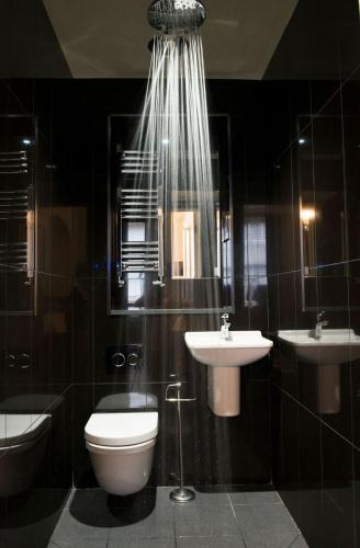 a bathroom with a toilet and a sink and a mirror at East Walls Hotel in Chichester
