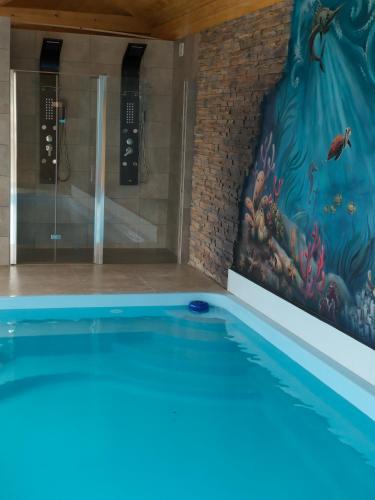 a swimming pool with a painting on the wall at Willa Myśliwska dom 10-osobowy ZE STREFĄ BASENOWĄ w miejscowości Chocznia NIEDALEKO ZATORU I ENERGYLANDII in Chocznia