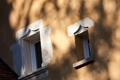 two windows on the side of a building at Castel Damandre - Demeures & Châteaux in Arbois