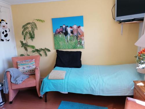 een slaapkamer met een bed en een stoel bij B&B Bij de koeien in Tubbergen
