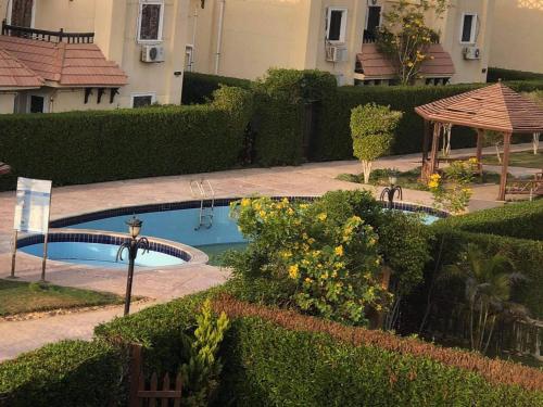 a garden with a swimming pool and a gazebo at فيلا الساحل الشمالى Villa North coast Marseilia Beach 3 " Families Only" in Alexandria