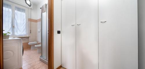 ein weißes Bad mit einem WC und einem Fenster in der Unterkunft Tasso 47 Apartment in Pavia