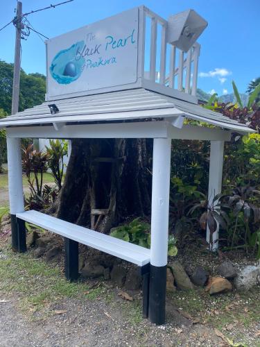 a bench sitting in front of a tree at The Black Pearl Beachside Apartments in Rarotonga