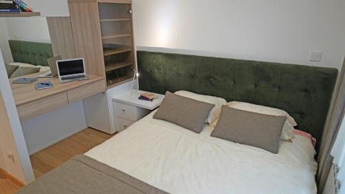 a bedroom with a large bed with a green headboard at Captain's Apartment in Karaburma