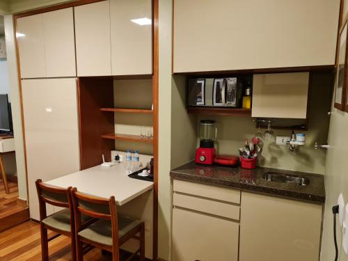 una pequeña cocina con mesa y barra en (109)Flat Poeta Drummond Jardins (Apt Particular), en São Paulo