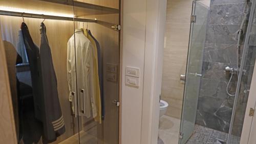 y baño con cabina de ducha y albornoz. en Captain's Apartment en Karaburma