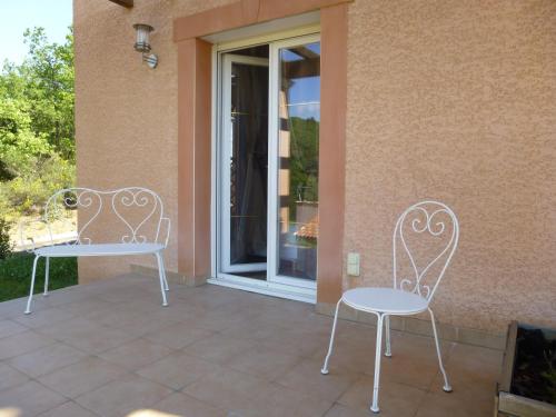 two white chairs sitting on a patio next to a building at Domaine de Flo ADULT a partir de 16 ans in Saint-Jean-de-la-Blaquière