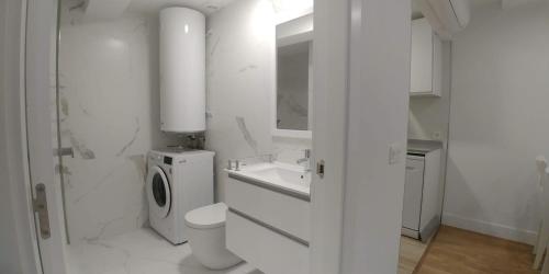 biała łazienka z toaletą i umywalką w obiekcie Cómodo apartamento en zona antigua dos w mieście Pontevedra