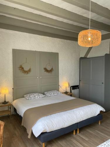 a bedroom with a large bed with two pillows at Hôtel et RESTAURANT traditionnel L' Escalandes in Lesperon